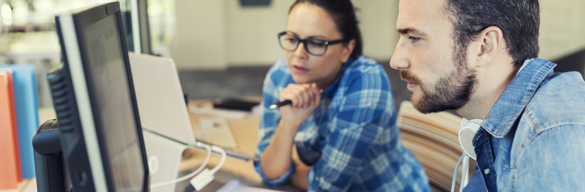 Young man and woman studying computer screen for customer relationship management, CRM.