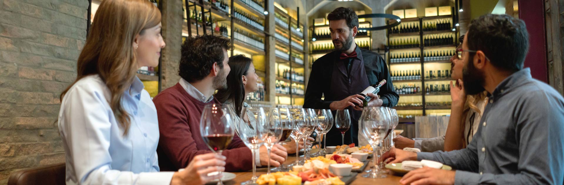 Group of wine tasters listening to sommalier discussing a wine varietal.